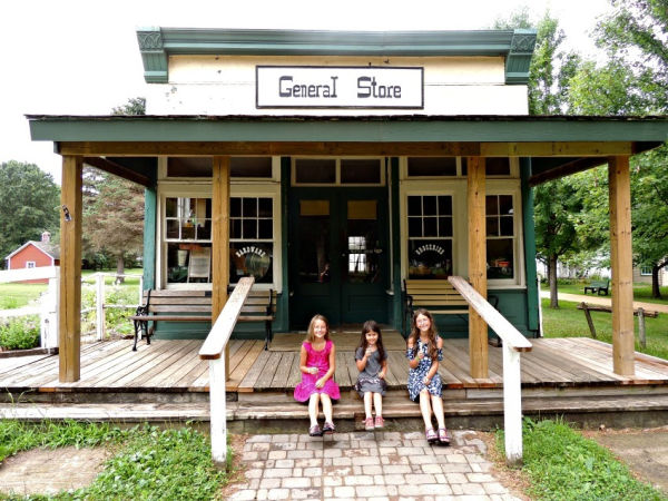 Girls enjoying snacks outside the General Store at Dakota City Heritage Village in Farmington MN