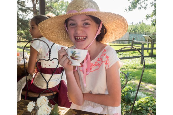 Girl drinking tea at a Gibbs Farm Summer Camp