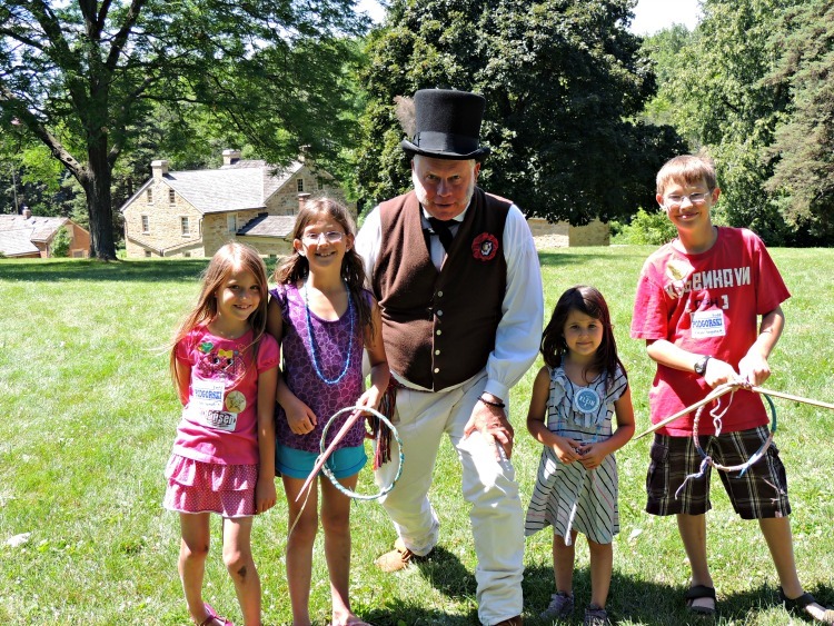 Kids learning about traditional toys from a costumed tour guide at the Sibley Historic House in Mendota Heights, Minnesota - Twin Cities Museums & Historic Sites