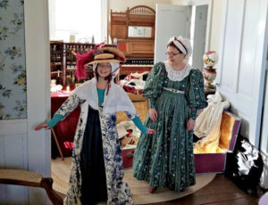 Tween girl and costumed guide dressing up in period clothing at the Pond Dakota Mission Park in Bloomington MN