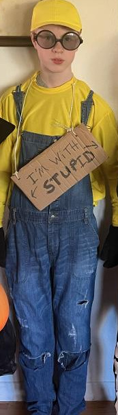 Teen boy dressed as a Minion. Sign says "I'm with Stupid"