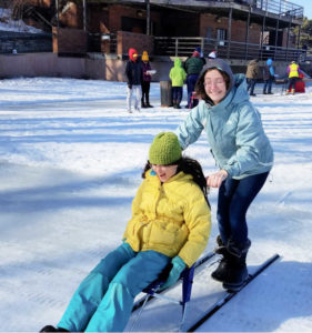 Two girls kicksledding on ice