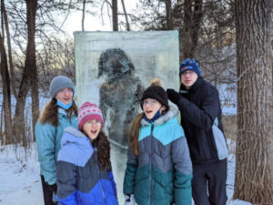 Kids posing in front of the "cave man" in Theodore Wirth Park, Minneapolis