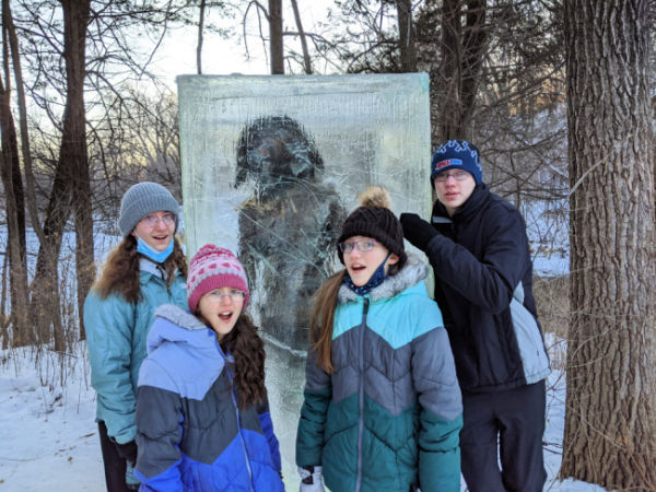 Kids posing in front of the "cave man" in Theodore Wirth Park, Minneapolis