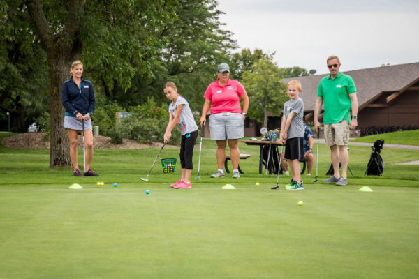 Children and adults learning to golf at Baker National Golf Course, Medina, Minnesota.