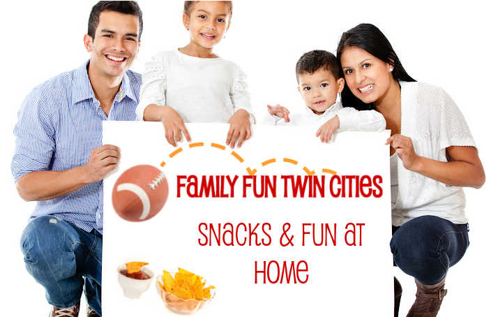 Family holding a football sign that says, "Family Fun Twin Cities - Snacks and Fun at Home"
