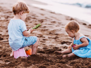 Two small children digging a moat on the beach