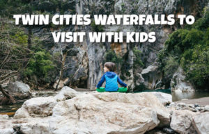 Boy viewing waterfall from nearby rock formation - Twin Cities Waterfalls to Visit With Kids