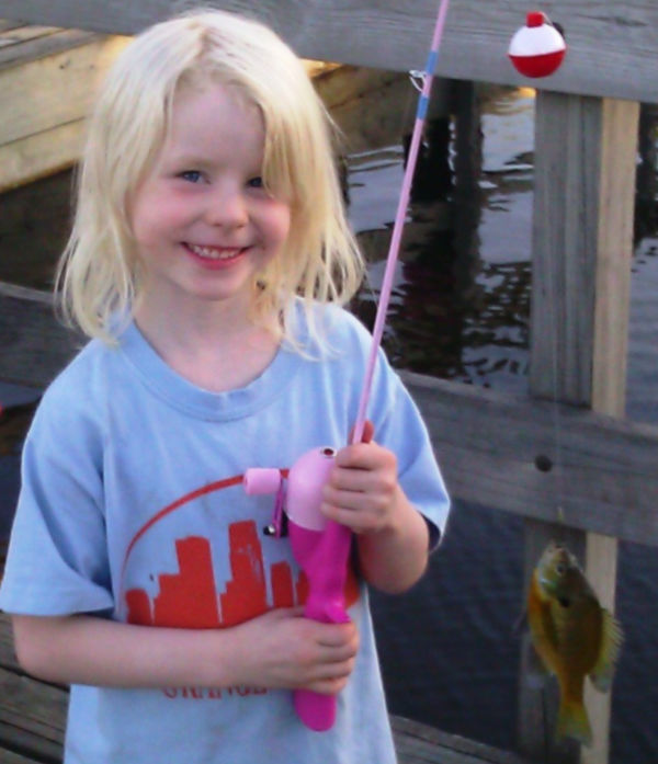 Young girl with a sunfish on her line, fishing at Central Park in Roseville Minnesota
