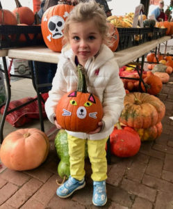 Girl with pumpkin at the pumpkin decorating station at Lowertown Farmers Market in St. Paul, Minnesota