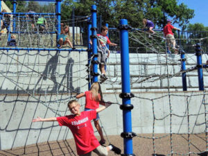Boy playing on netting playground at Hyland Lake Park in Bloomington Minnesota