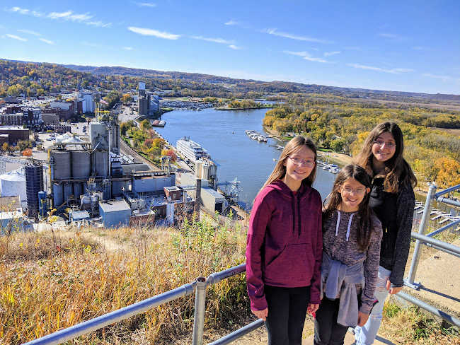 Three girls standing in front of the overlook at Barn Bluff in Red Wing, Minnesota