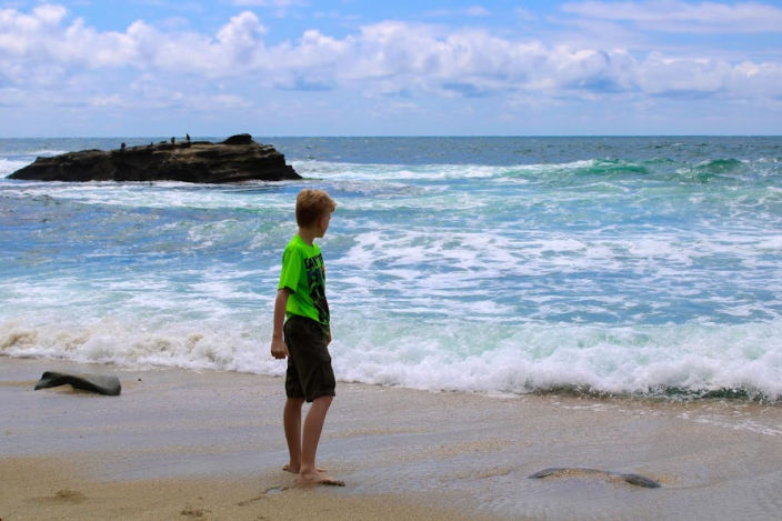 boy standing on the shore in La Jolla Beach