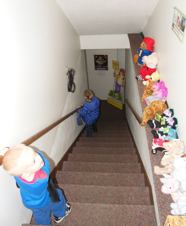 Kids walking down stairway to the basement of the Red Balloon Bookshop in Saint Paul, Minnesota