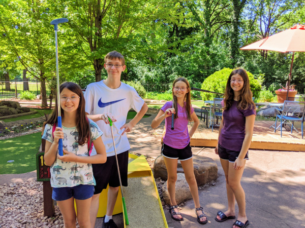 Four teens playing Mini Golf at Como Park in St. Paul, Minnesota