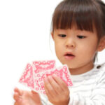 Girl holding a hand of playing cards