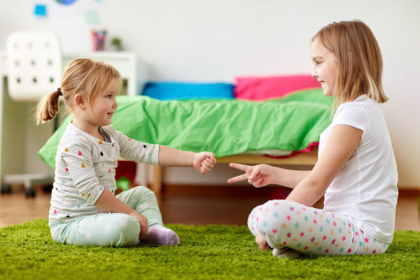 Two girls playing rock, paper, scissors