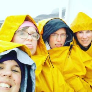 4 wet, cold women outside on the boat in the middle of the Atlantic ocean