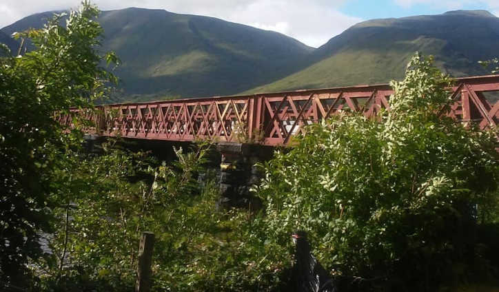 red railroad bridge in scotland's highlands