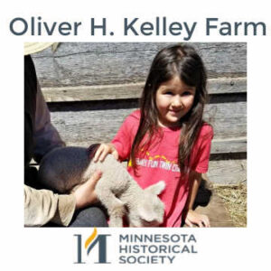 Small girl petting lamb at Oliver H. Kelley Farm in Elk River, Minnesota