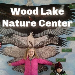 Wood Lake Nature Center - Background Image: Two Kids measuring arm span against raptor wing span