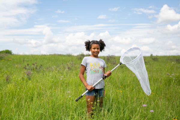Girl with a butterfly net in a field. Image courtesy of Three Rivers Park System Summer Camp Programs