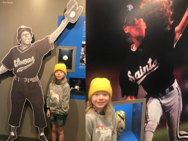Girl posing in front of exhibits of Toni Stone and Ila Borders at the City of Baseball Museum in CHS Field, St. Paul, MN