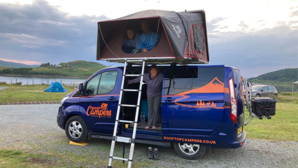 Family peeping out of Rooftop Campers campervan on the Isle of Skye