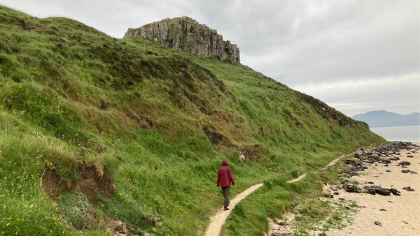 Boy walking a trail to Coral Beach on Isle of Skye, Scotland