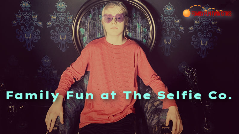 Pale boy in gothic chair. Text reads: "Family Fun at the Selfie Co. Family Fun Twin Cities."