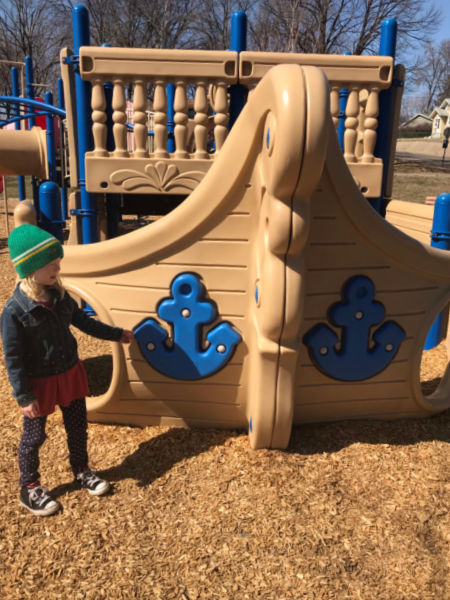 Girl playing on the pirate ship playground at Ostrander Park in Columbia Heights, MN